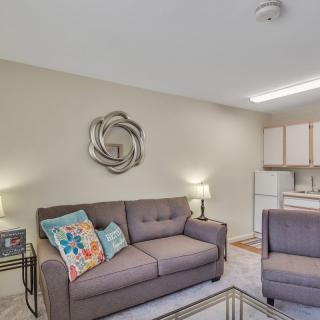 A cozy living room with a comfortable sofa and decorative pillows adjacent to a kitchen area.