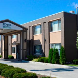 A well-maintained hotel building with a welcoming entrance and clear blue skies.