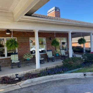 An inviting porch with chairs and hanging plants.