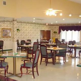 A spacious dining area with neatly arranged tables and chairs, well-lit by overhead lights.