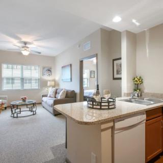 A modern and bright apartment interior featuring an open-plan living room and kitchen area.