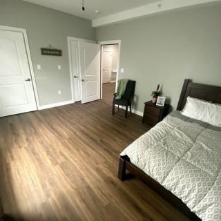 A minimalist bedroom with modern decor and wood flooring.