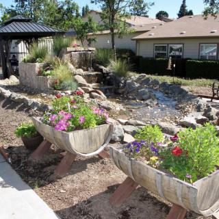A beautifully landscaped garden with flower planters in a backyard setting.