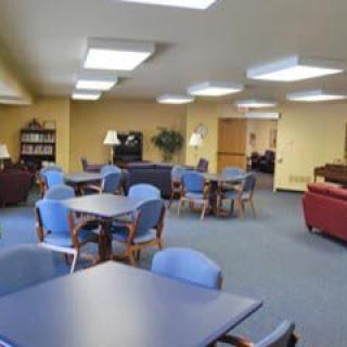 A spacious lounge area with tables and chairs arranged for seating.