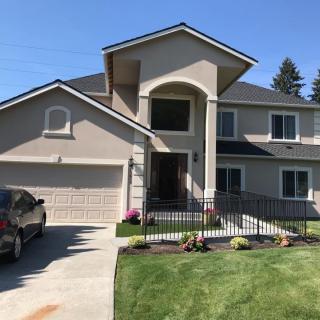 A modern two-story house with a driveway and neatly landscaped lawn.