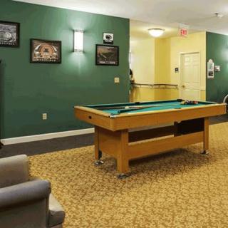 A cozy game room featuring a pool table and comfortable seating.