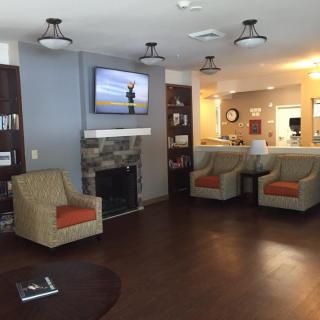 A cozy living room area with comfortable chairs, a fireplace, and a television.
