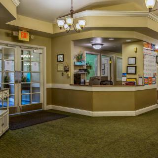 A spacious reception area with a central desk and bright lighting.