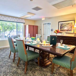 A well-decorated dining room with a set table and comfortable chairs.