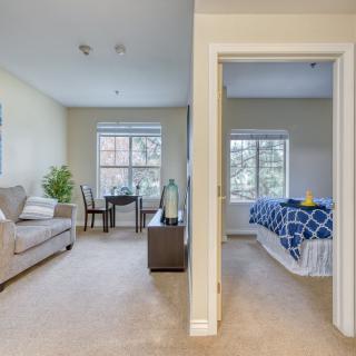 A cozy interior featuring a living room with a sofa and a table, adjacent to a bedroom with a neatly made bed.