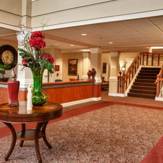 A well-decorated lobby with a table centerpiece and stairs in the background.