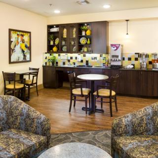 A cozy cafe with a seating area and a coffee station.