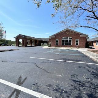 A brick building with a parking lot under a clear blue sky.