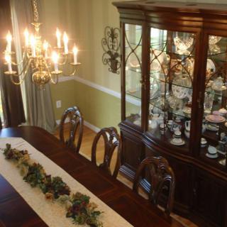 A beautifully decorated dining room featuring an elegant chandelier and a classic china cabinet.