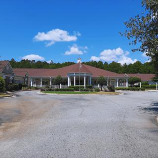 A large building surrounded by trees with a clear blue sky above.