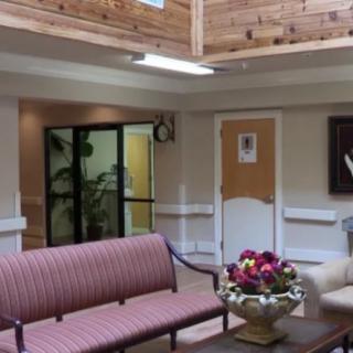A cozy lobby area featuring a striped sofa and floral arrangement on a coffee table.