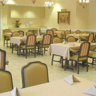 An empty dining room with tables and chairs neatly arranged, ready for guests.