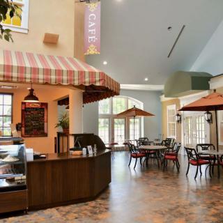 A cozy cafe interior with tables, chairs, and decorative umbrellas.
