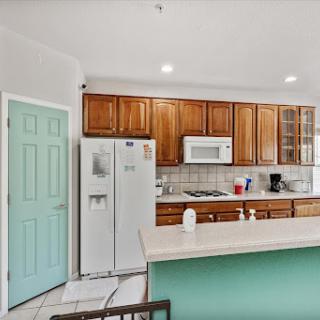 A cozy kitchen featuring wooden cabinets, modern appliances, and a welcoming breakfast bar.