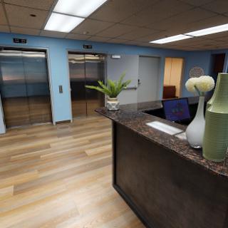 A modern office reception area featuring elevators and a stylish desk.