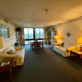 A spacious living room featuring comfortable seating, a dining area, and ample natural light.