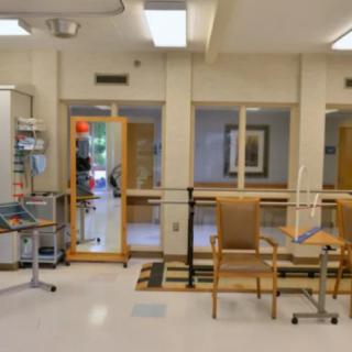 A hospital waiting area with chairs, doors, and bright lighting.