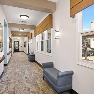 A modern hallway with windows and benches, featuring stylish lighting.