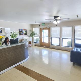 A bright office reception area with a desk and seating.