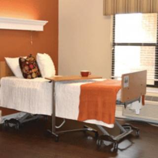 A hospital room with a bed, featuring an orange and white color scheme.