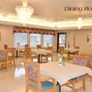 A bright and spacious dining room with neatly arranged tables and chairs.