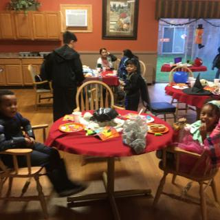 A festive gathering with children enjoying a meal around a decorated table.