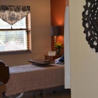 A cozy and well-lit hospital room with a neatly made bed and decorative elements.