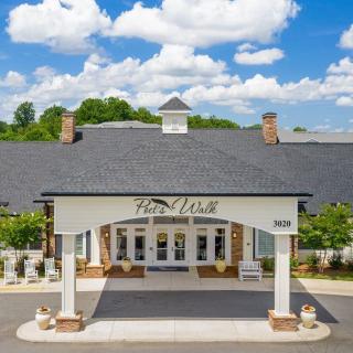 Front view of an elegant building entrance under a partly cloudy sky.
