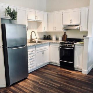 A modern kitchen with white cabinets and stainless steel appliances.