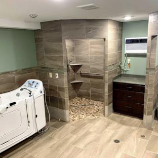 A modern wellness bathroom featuring hydrotherapy equipment and a spacious shower area.