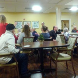 A lively gathering in a dining hall, where individuals are engaged in conversation and enjoying their time together.