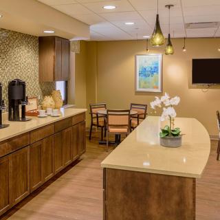 A modern kitchen interior with a countertop, pendant lighting, and a seating area.