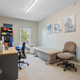 A well-organized office space featuring a desk, chairs, and decorative artwork on the walls.