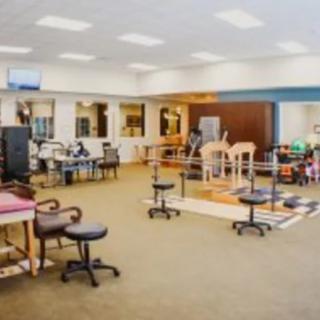 A spacious physical therapy and rehabilitation center with exercise equipment.