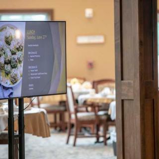 A digital menu displayed near a dining area in a restaurant.