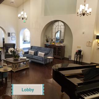 A beautifully decorated hotel lobby featuring elegant furniture and a grand piano.
