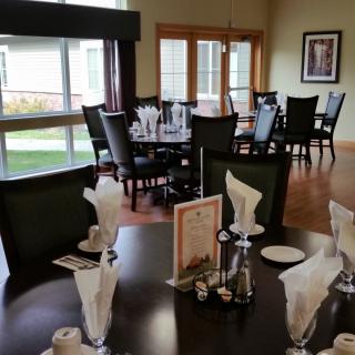 An elegantly set dining room with neatly arranged tables and chairs near large windows.