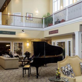 A spacious lobby with a grand piano and comfortable seating areas.