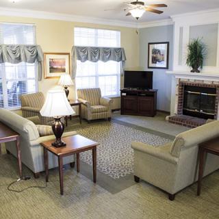 A cozy living room with sofas, a fireplace, and a television.