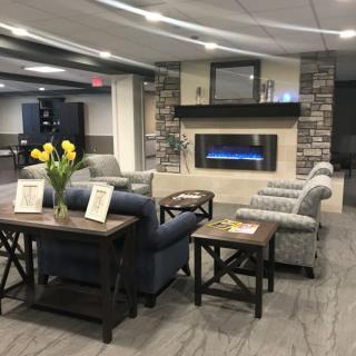 A modern living room with a sofa, chairs, and a fireplace.