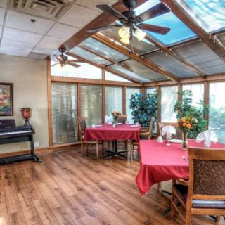 A cozy dining area featuring red table settings and ample natural light, perfect for enjoying a meal.