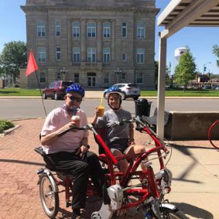 Enjoying a sunny day with ice cream on a tandem bicycle.