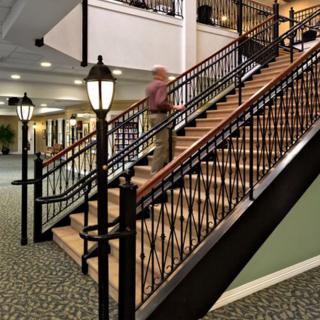 A stylish interior with a decorative staircase featuring ornate railings and lamps.