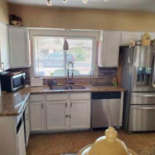 A modern kitchen with white cabinets and stainless steel appliances.