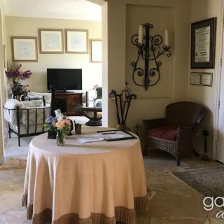 A cozy living room with a round table, chairs, and decorative wall art.